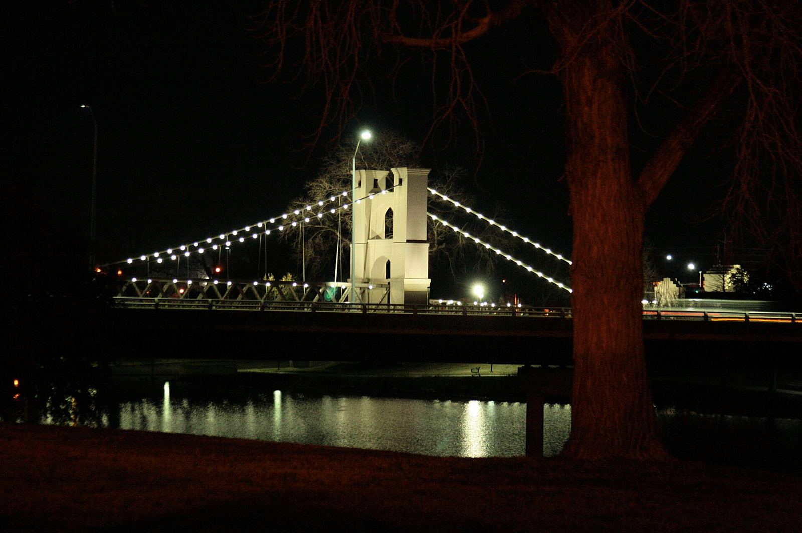 The Waco Suspension Bridge lit at night above the Brazos River.