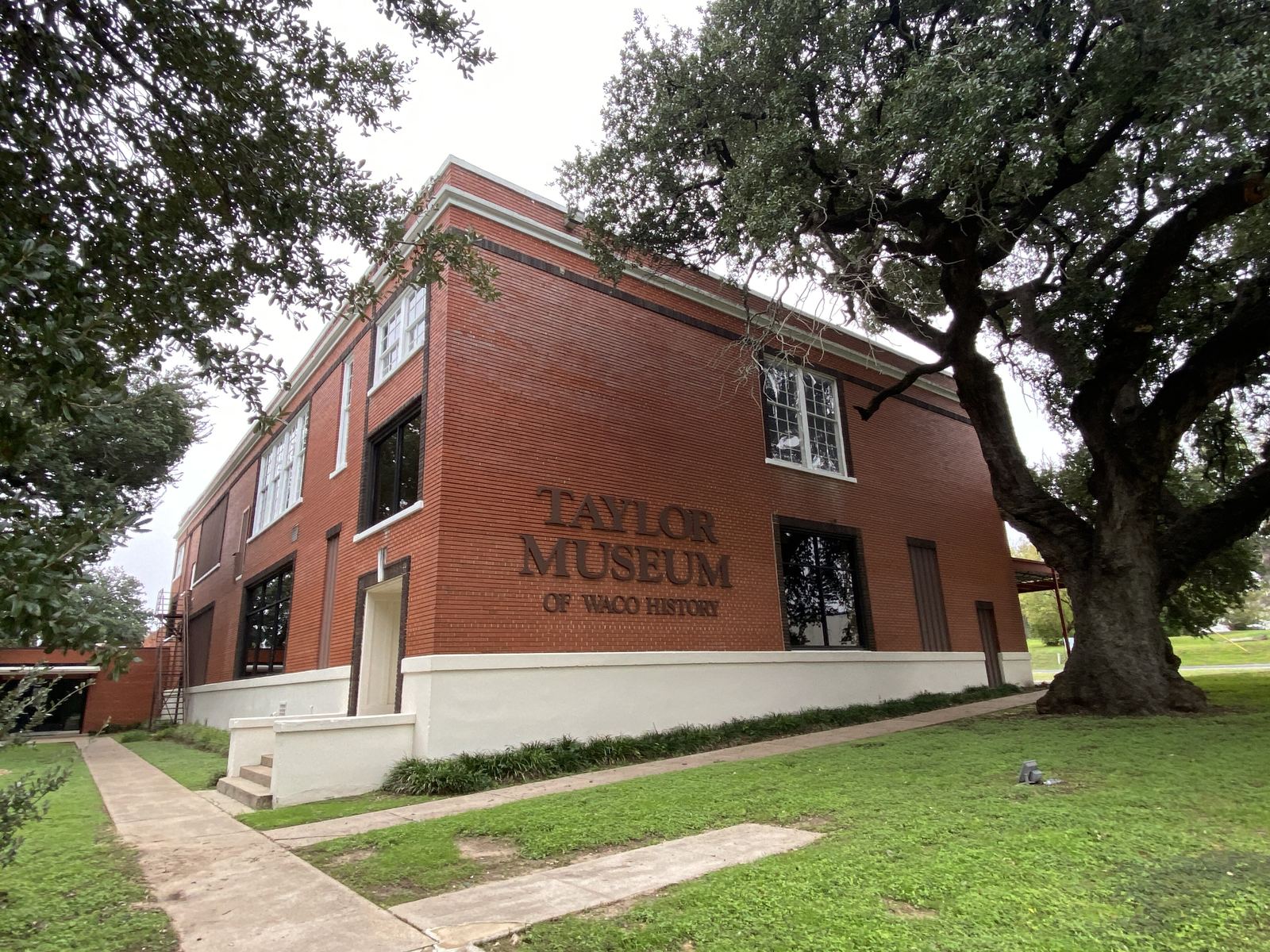 The Taylor Museum of Waco History, a red brick building beneath a live oak.